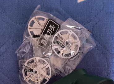 USB Rechargeable Lint Remover replacement blades in packaging on blue fabric.